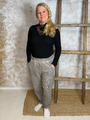 Stretch-housut reilulla mitoituksella, paljettikoristeiset lahkeet, korkea kuminauhavyötärö, taskut, kapeneva lahje