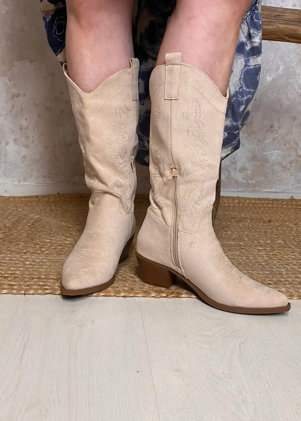 Beiget kirjaillut bootsit mokkamaisella pinnalla, pehmeällä vuorella ja sisäsivun vetoketjukiinnityksellä.