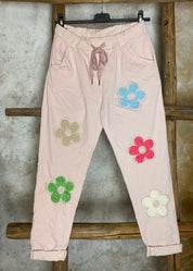 Naisten stretch-housut kukkakuvioilla ja strasseilla, kuminauhavyötärö, taskut edessä, kapenevat lahkeet.