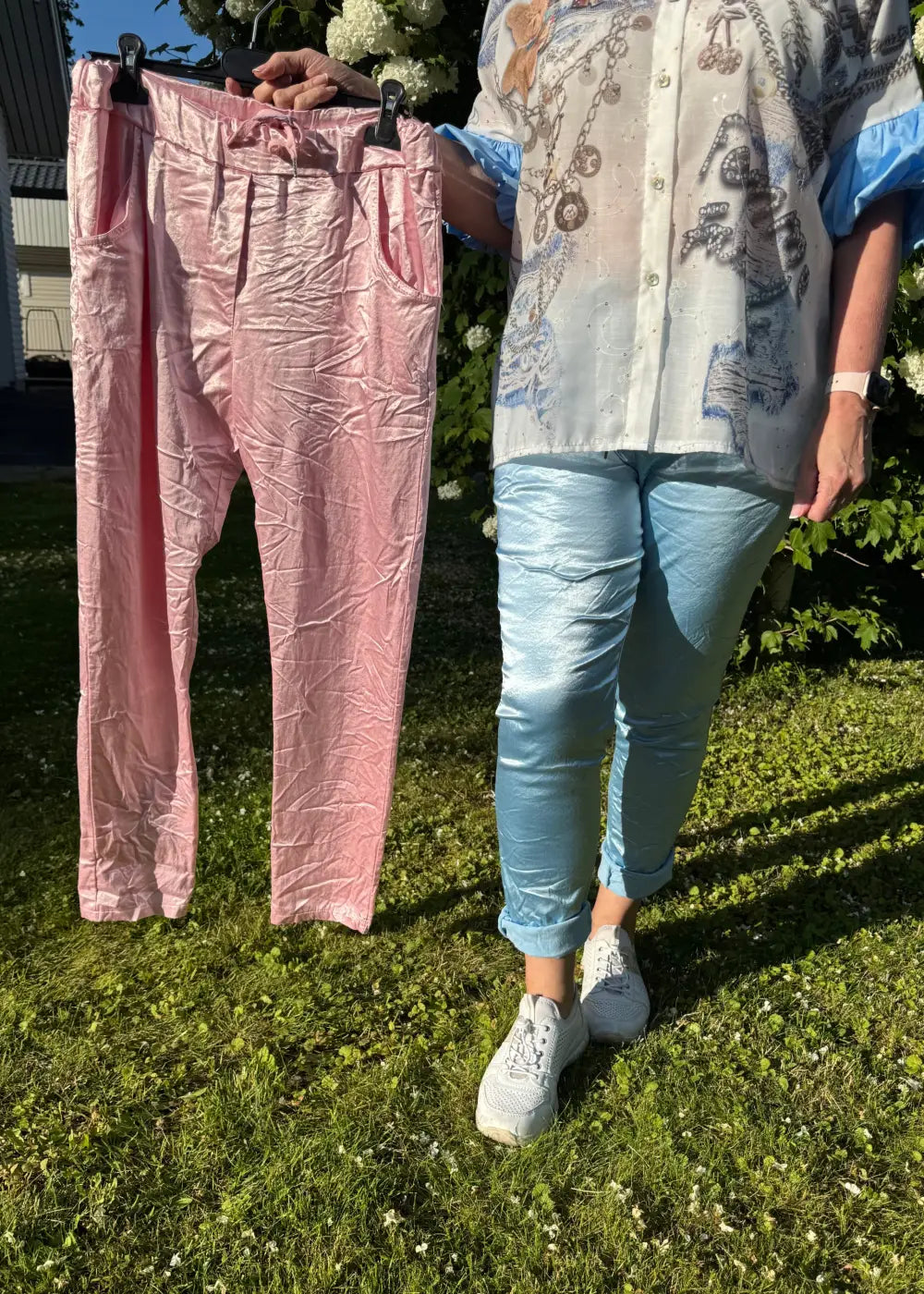 Kiiltäväpintaiset stretch-housut, kuminauhavyötärö, taskut edessä ja takana, joustavat, sopii kokoihin 38–44, viskoosisekoite.