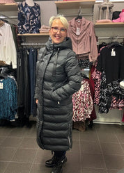 Naisten musta pitkä toppatakki, suora malli, huppu, sivuvetoketjut, lämmin ja tyylikäs valinta talven kylmiin päiviin.