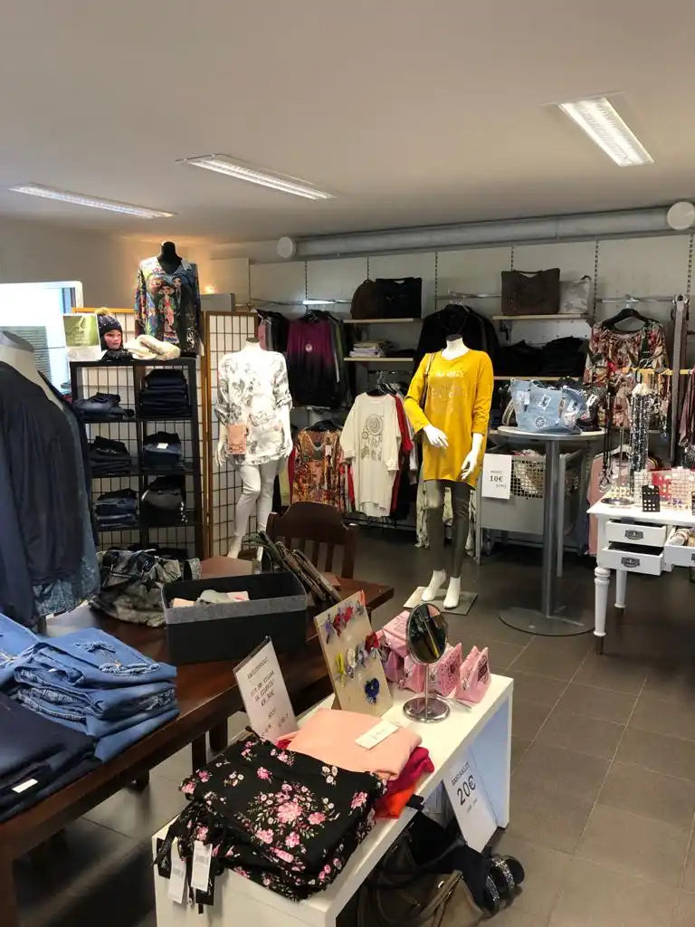 Vaatekauppa, jossa on esillä erilaisia vaatteita ja asusteita.