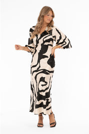 Naisten ylellinen satiinimekko shamppanjan sävyisellä pohjalla, musta abstrakti kuviointi, leveät puhvihihat, poikkileikkaus vyötäröllä, levenevä helma ja halkio toisella sivulla, V-pääntie