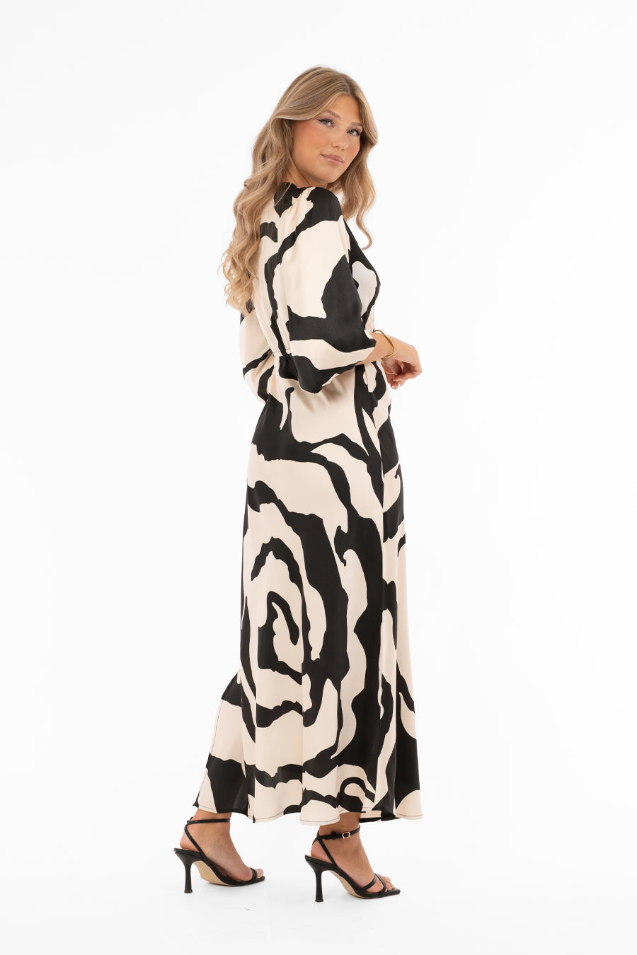 Naisten ylellinen satiinimekko shamppanjan sävyisellä pohjalla, musta abstrakti kuviointi, leveät puhvihihat, poikkileikkaus vyötäröllä, levenevä helma ja halkio toisella sivulla, V-pääntie