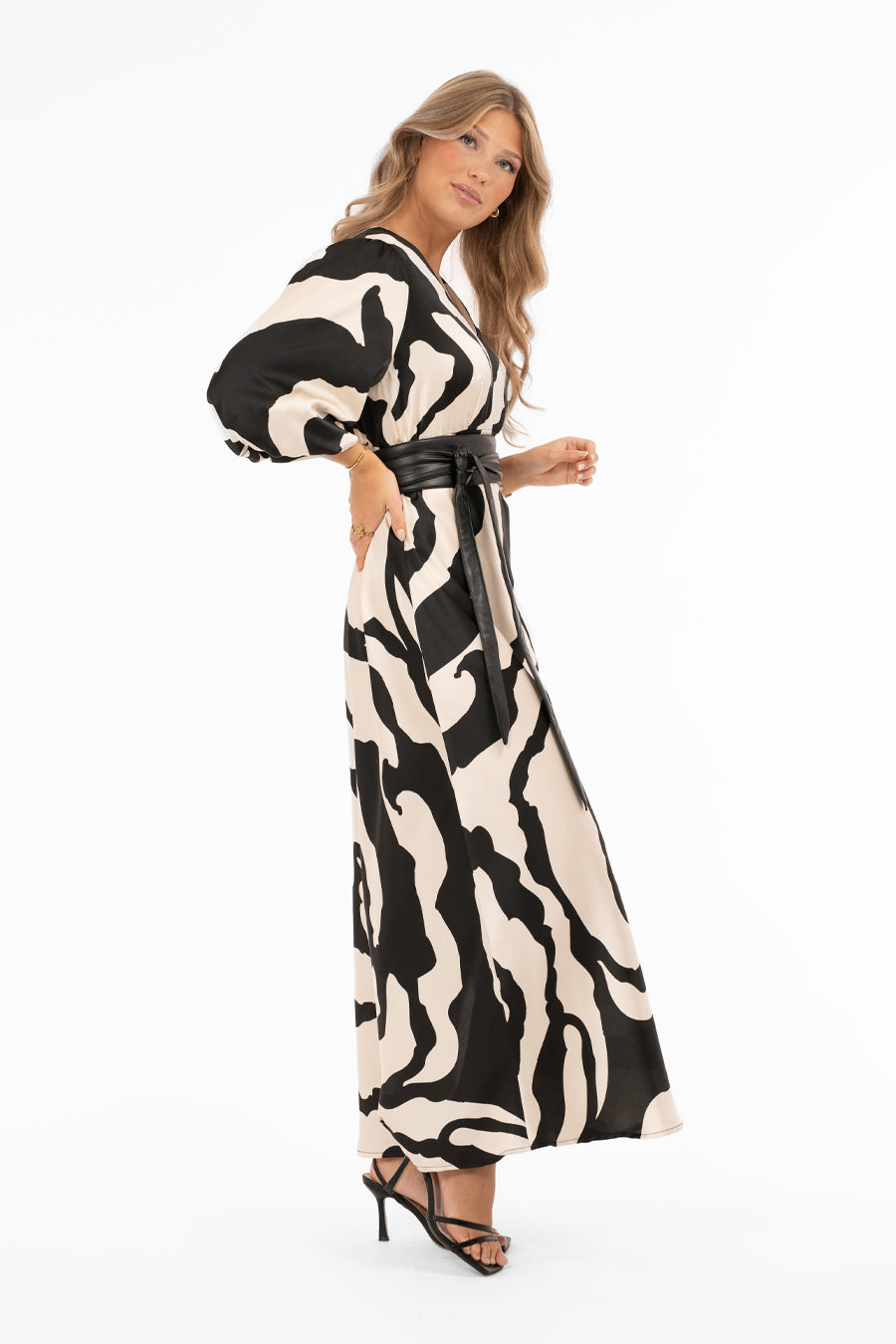 Naisten ylellinen satiinimekko shamppanjan sävyisellä pohjalla, musta abstrakti kuviointi, leveät puhvihihat, poikkileikkaus vyötäröllä, levenevä helma ja halkio toisella sivulla, V-pääntie