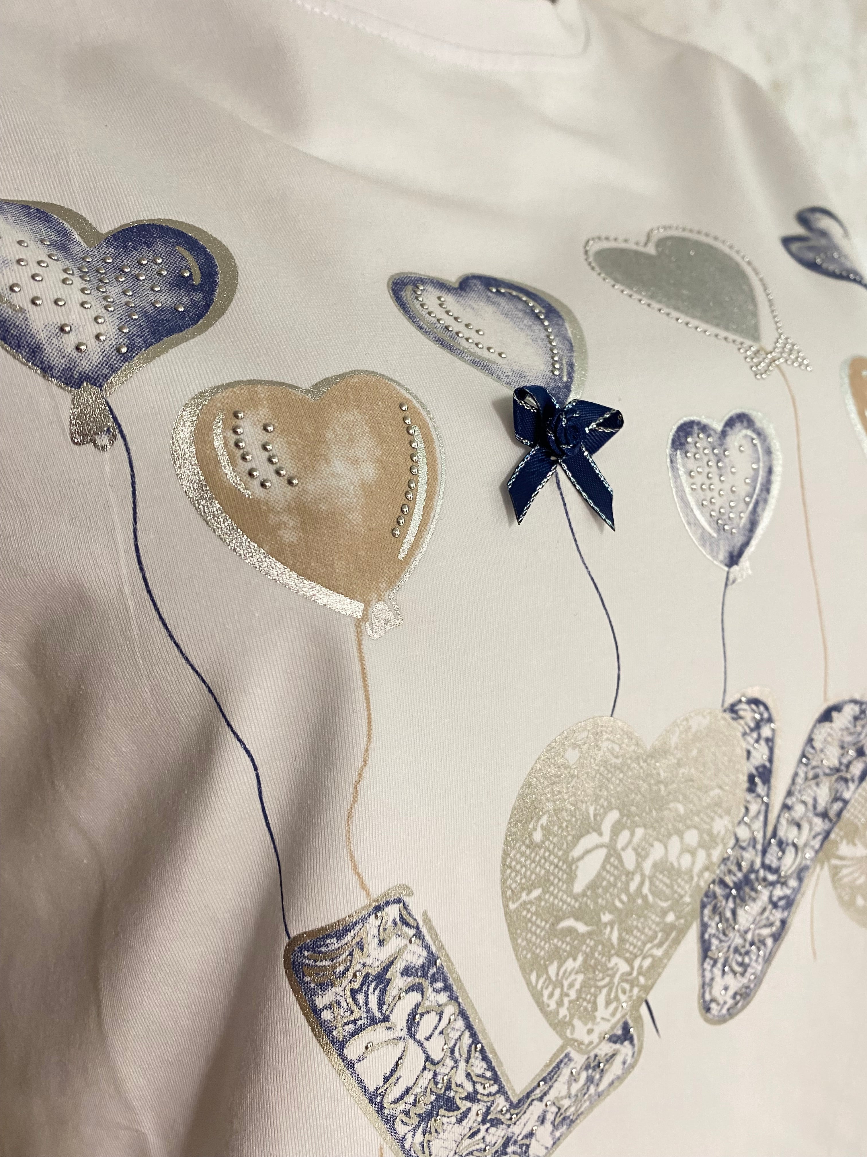 Naisten valkoinen t-paita strassikoristeisella printillä, joustava laadukas materiaali, naisellinen malli, käänteet hihoissa ja O-pääntie