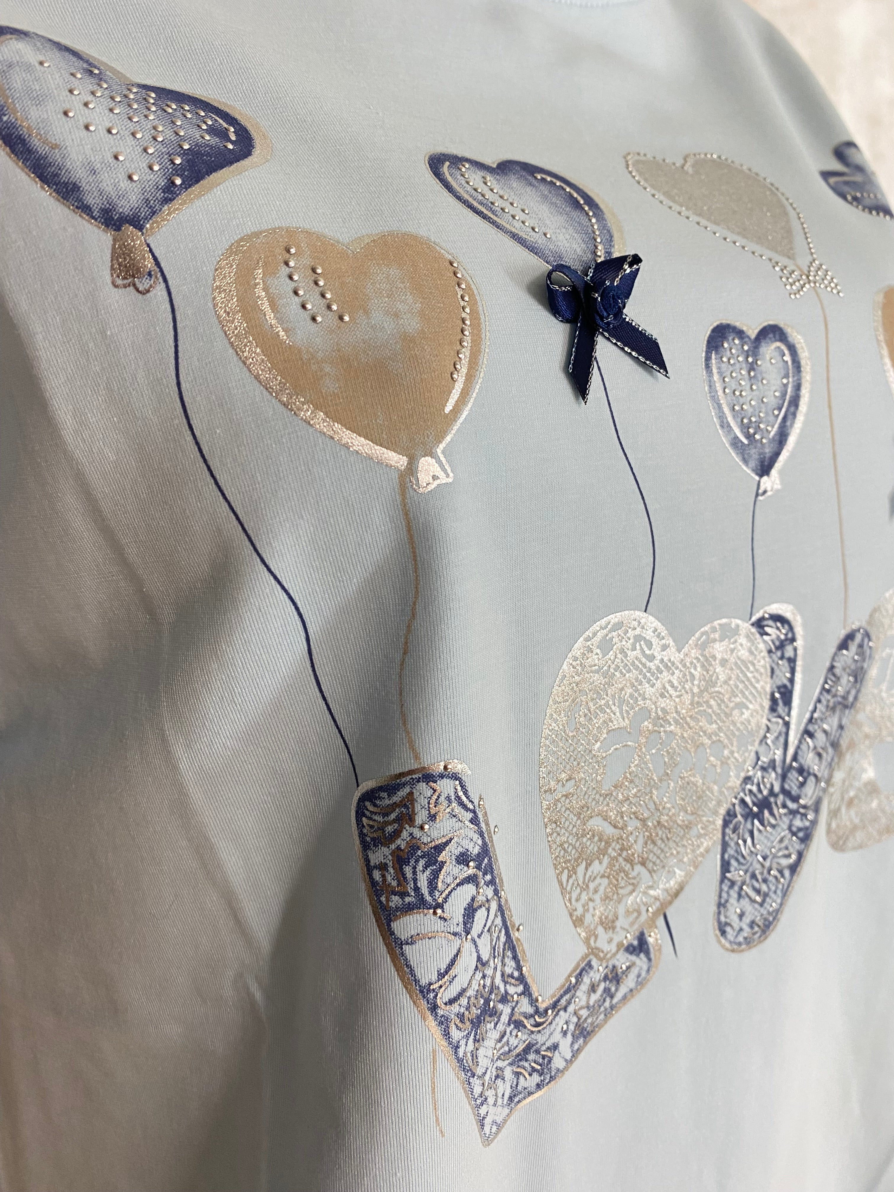 Naisten vaaleansininen t-paita strassikoristeisella printillä, joustava laadukas materiaali, naisellinen malli, käänteet hihoissa ja O-pääntie