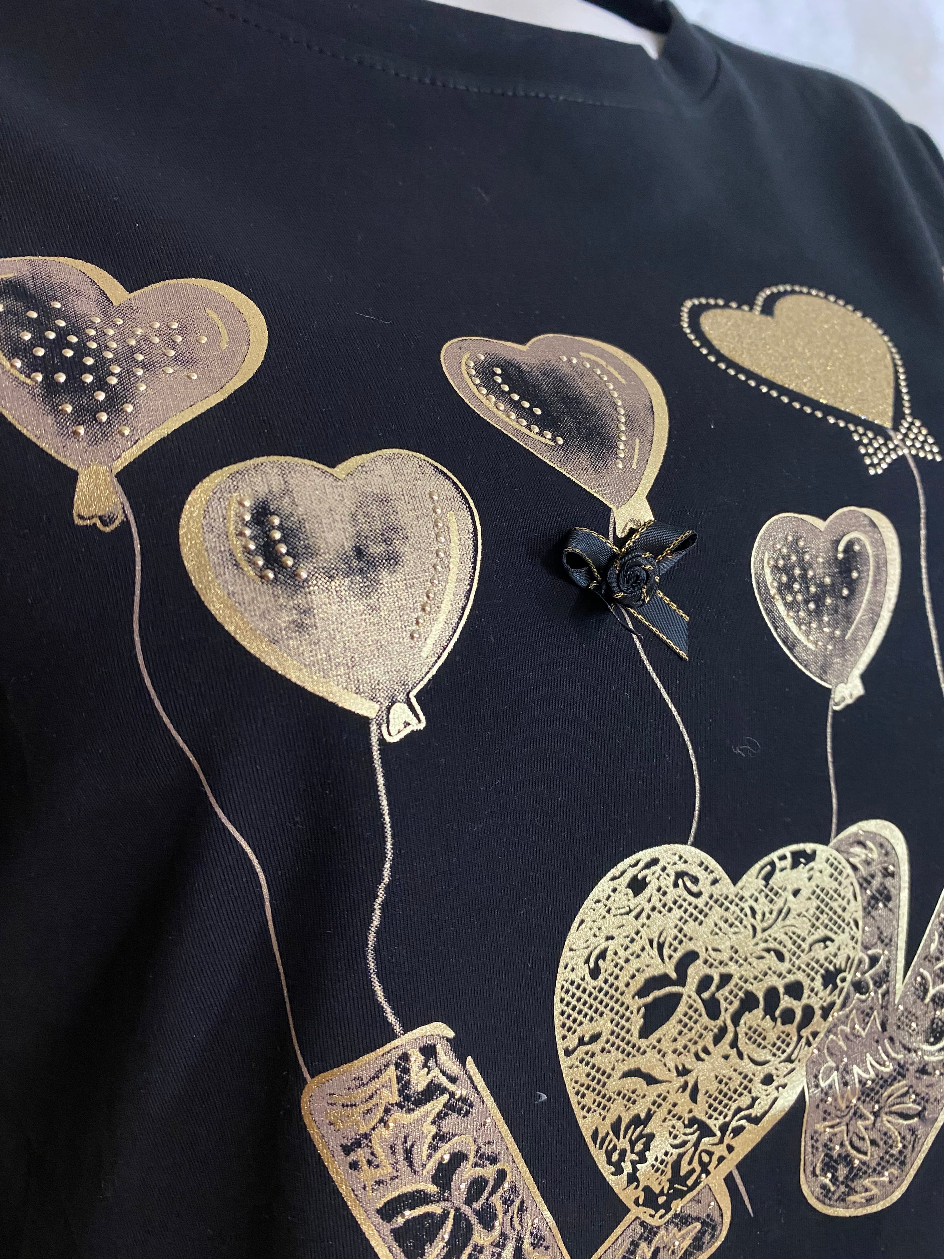 Naisten musta t-paita strassikoristeisella printillä, joustava laadukas materiaali, naisellinen malli, käänteet hihoissa ja O-pääntie