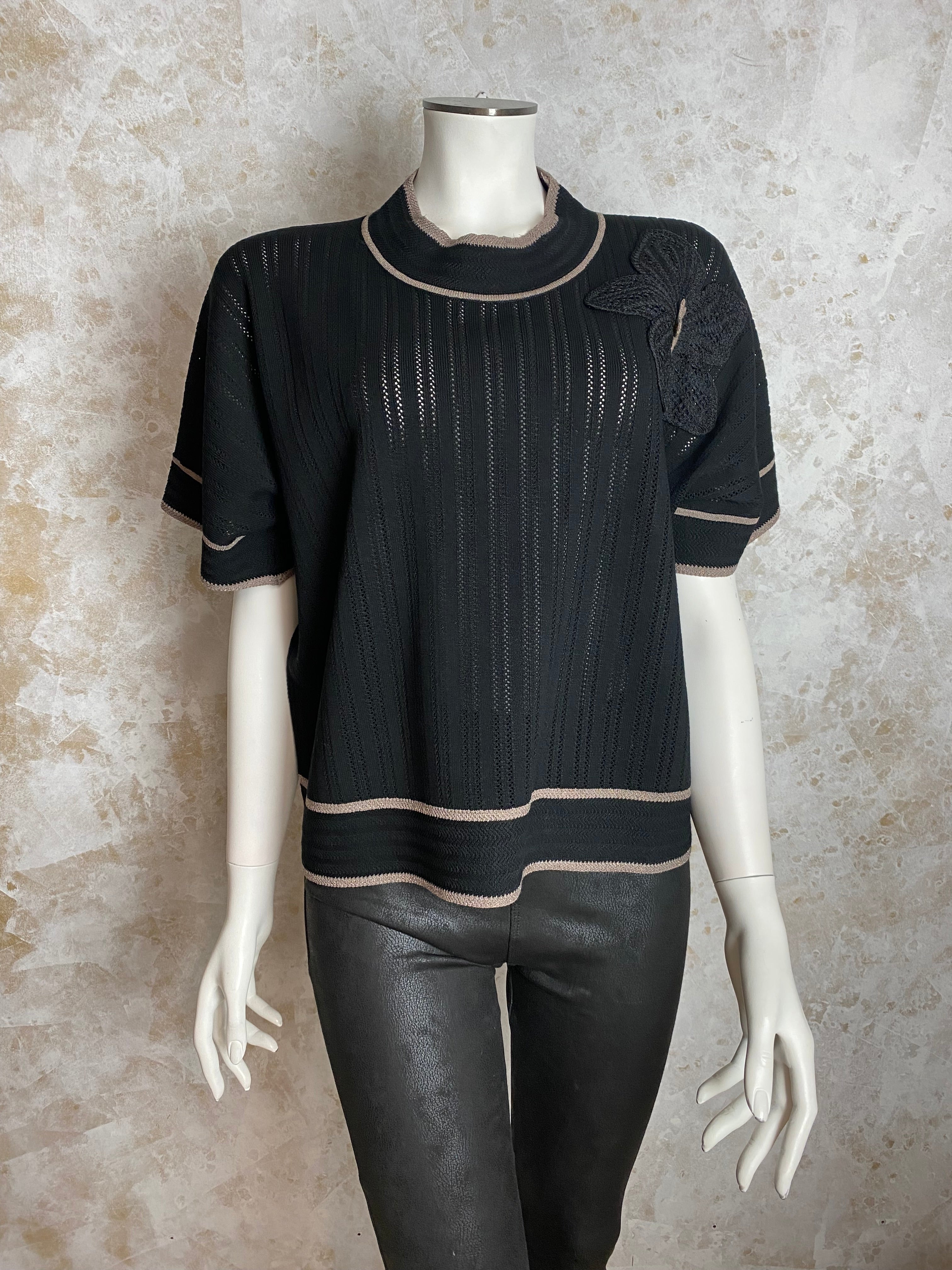 Naisten musta neule strassikukalla, paksu pehmeä materiaali, suora malli, pystykaulus, O-pääntie ja kimaltavat resorit