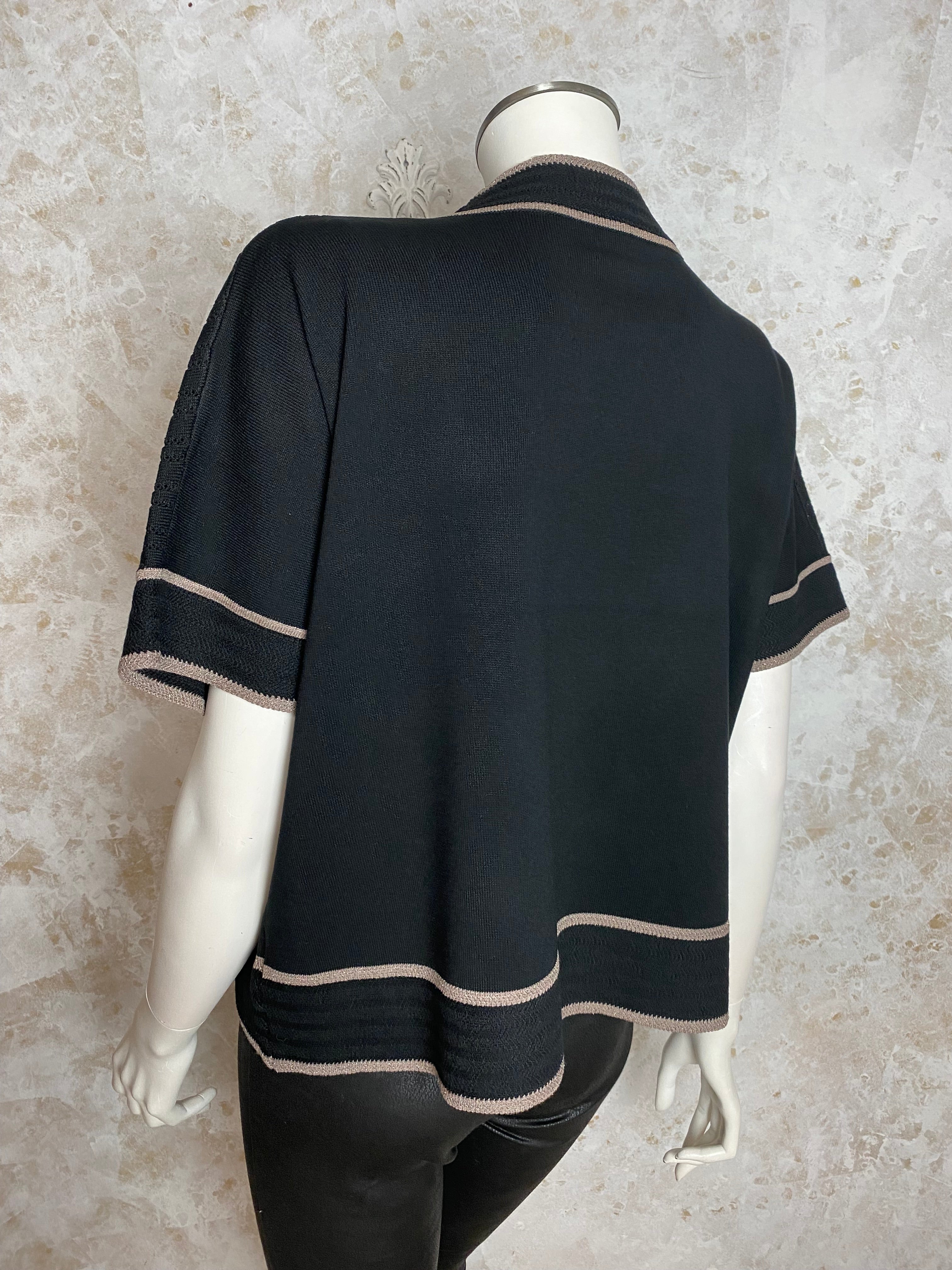 Naisten musta neule strassikukalla, paksu pehmeä materiaali, suora malli, pystykaulus, O-pääntie ja kimaltavat resorit