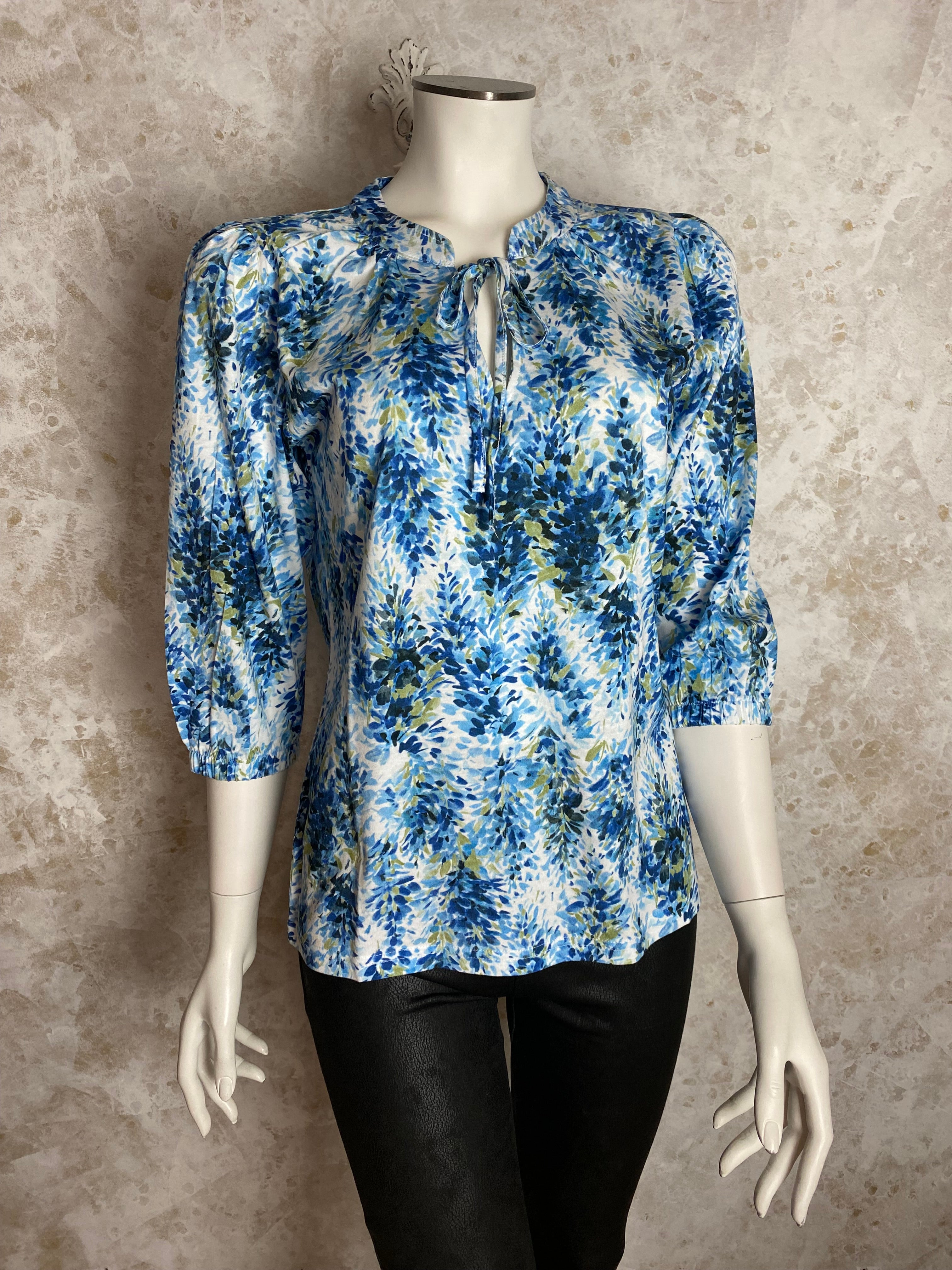 Naisten kirjava paita, pehmeä joustava materiaali, O-pääntie pienellä V-aukolla, kaulus ja nauhat, puhvihihat kuminauhalla