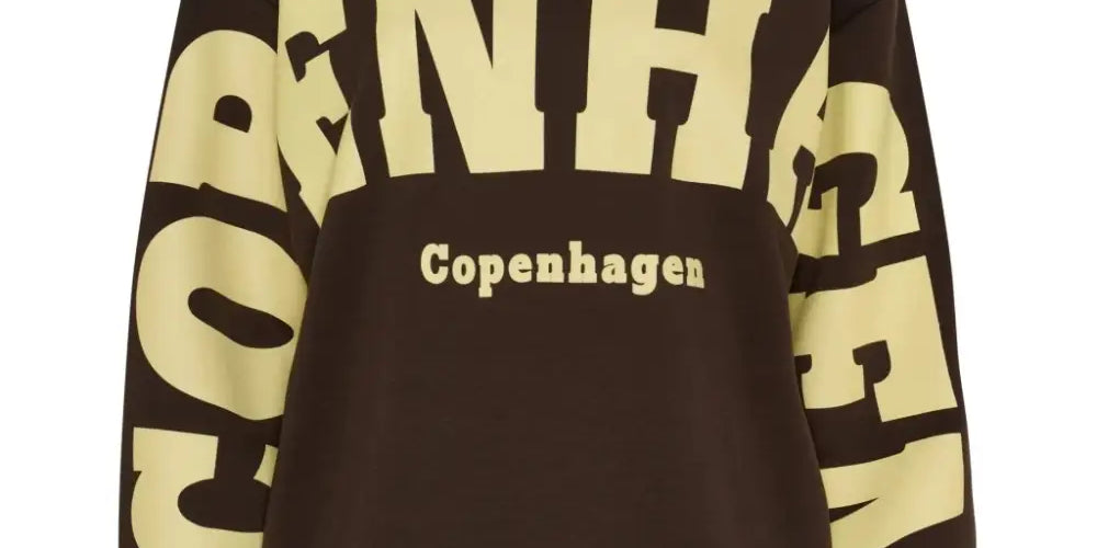 Ruskea-keltainen oversized collegepaita printtikuviolla, pehmeä ja joustava materiaali, pitkät hihat ja O-pääntie