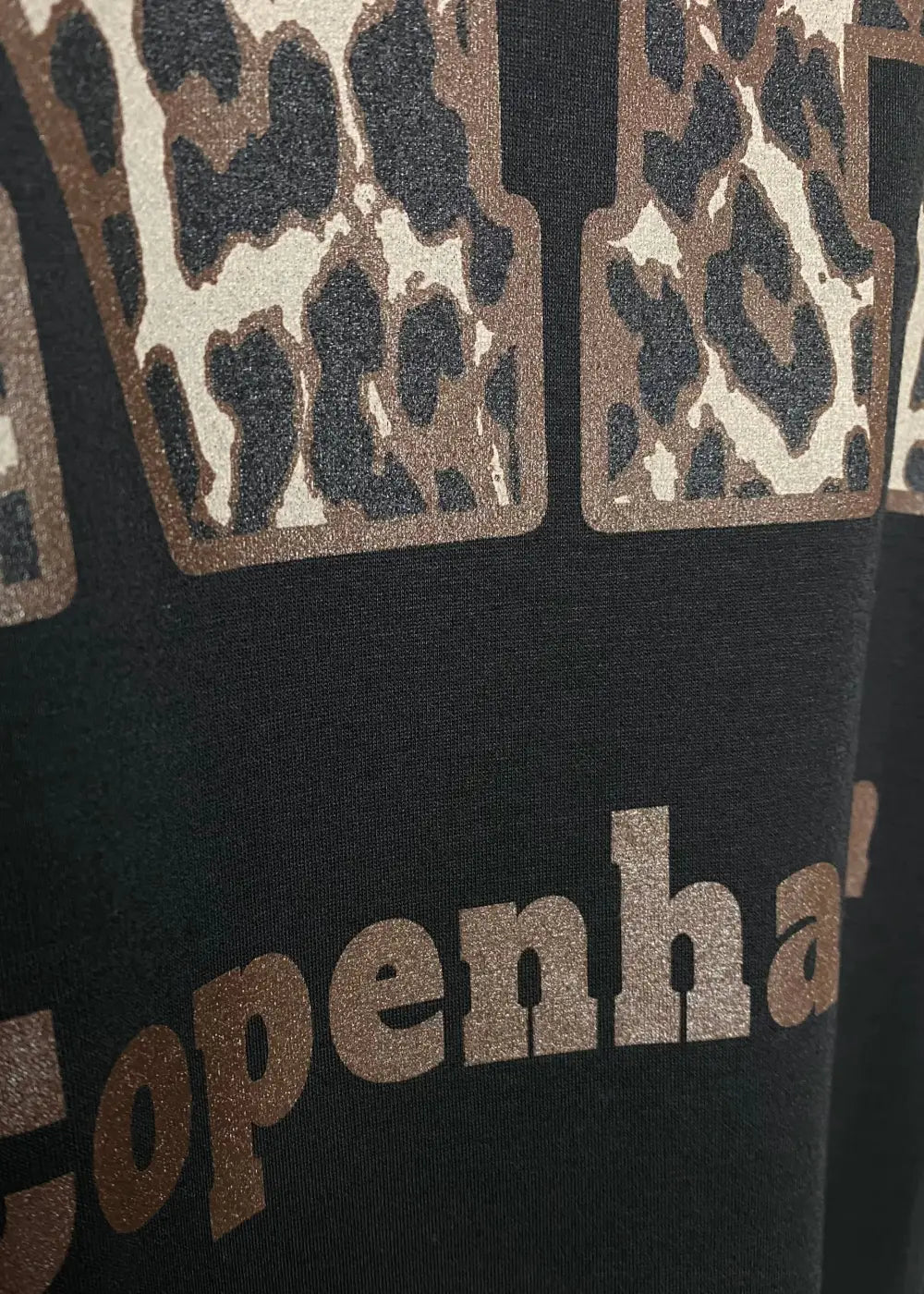 Musta oversized-collegemekko, jossa pehmeä joustava materiaali, Copenhagen-tekstiprintti, pitkät hihat ja lyhyet sivuhalkiot helmassa