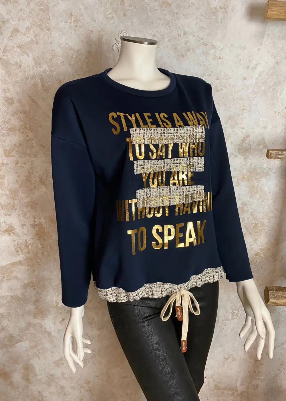 Naisellinen collegepaita, jossa kultainen teksti, koristeleikkaukset ja vohvelikangas helmassa, pehmeä ja joustava materiaali