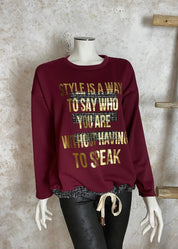 Naisellinen collegepaita, jossa kultainen teksti, koristeleikkaukset ja vohvelikangas helmassa, pehmeä ja joustava materiaali