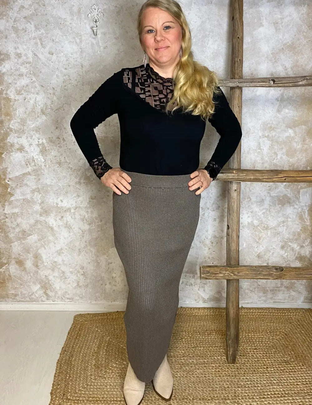 Pitkä taupen sävyinen neulehame, pehmeää ribbineulosta, joustava vyötärö ja istuva suora malli – mukava ja tyylikäs valinta.