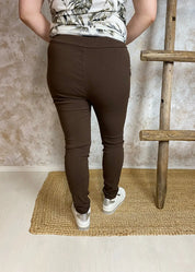 Naisten rennot stretch-housut ruskeana, korkea kuminauhavyötärö kiristysnarulla, edessä taskut ja kapeneva lahje