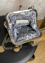 Kukkakuvioinen olkalaukku ketju- ja säädettävällä hihnalla, klipsikiinnitys ja hopeansävyiset yksityiskohdat