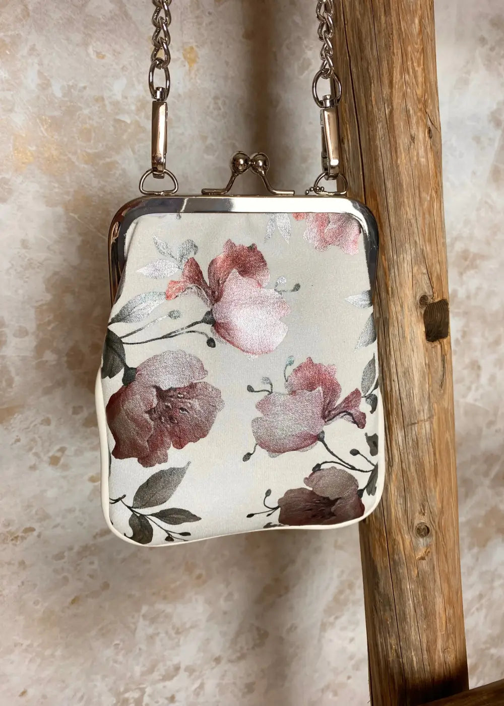 Kukkakuvioinen olkalaukku ketju- ja säädettävällä hihnalla, klipsikiinnitys ja hopeansävyiset yksityiskohdat