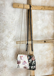 Kukkakuvioinen olkalaukku ketju- ja säädettävällä hihnalla, klipsikiinnitys ja hopeansävyiset yksityiskohdat