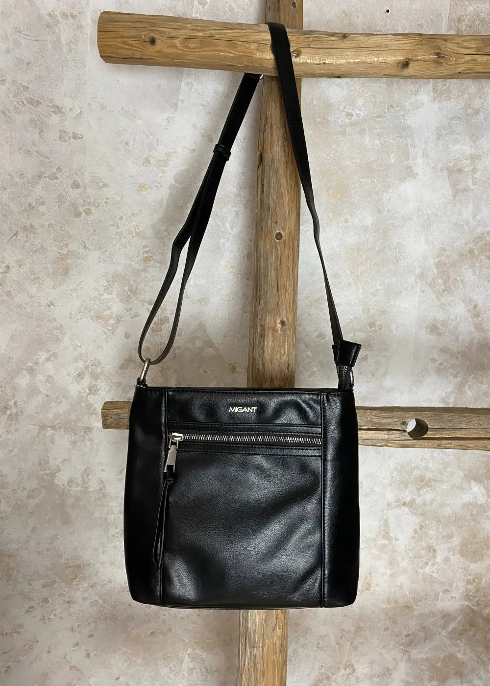 Klassinen musta olkalaukku keinonahkaa, säädettävä hihna ja vetoketjulliset taskut – tyylikäs ja käytännöllinen laukku.