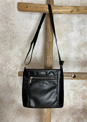 Klassinen musta olkalaukku keinonahkaa, säädettävä hihna ja vetoketjulliset taskut – tyylikäs ja käytännöllinen laukku.