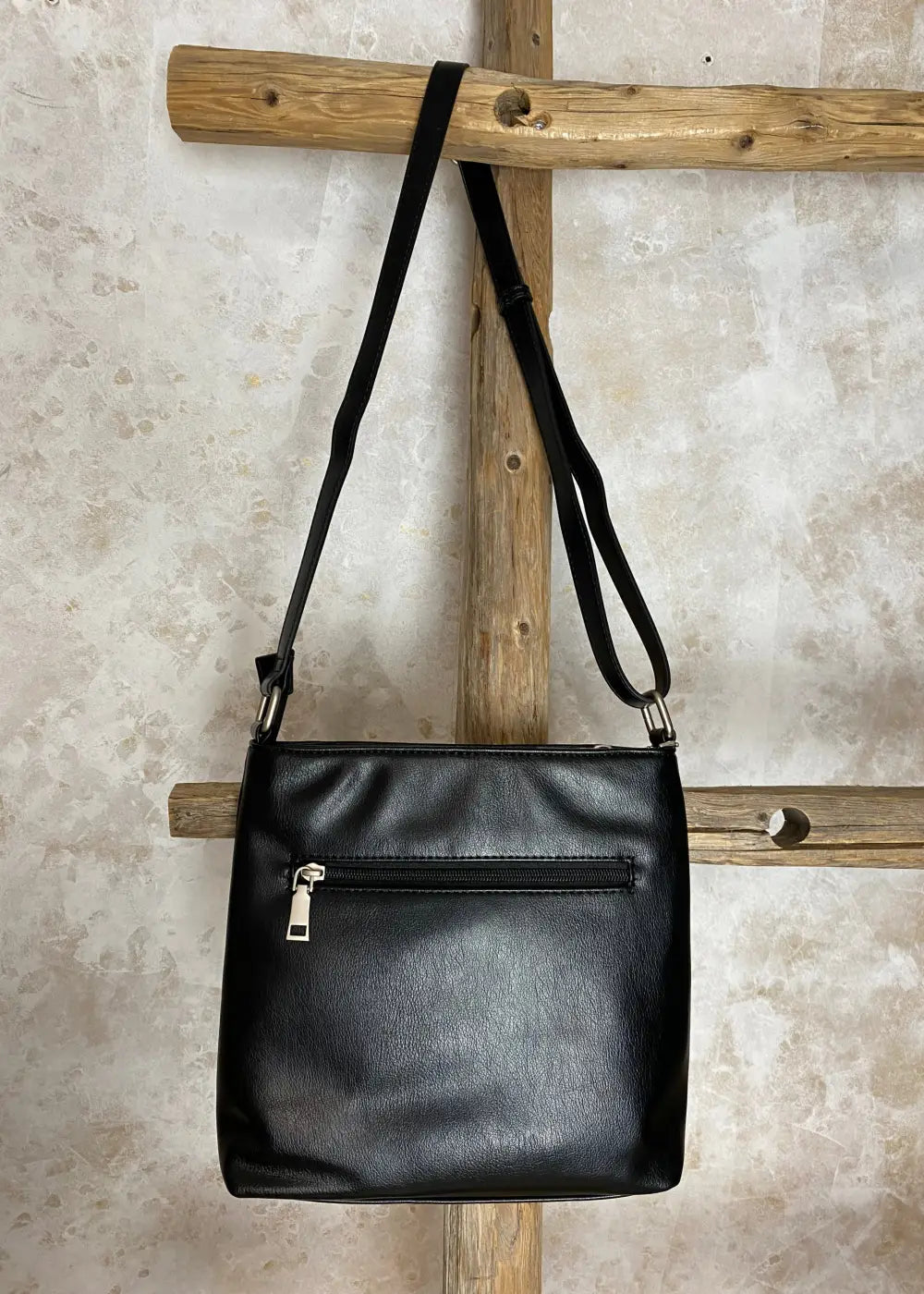 Klassinen musta olkalaukku keinonahkaa, säädettävä hihna ja vetoketjulliset taskut – tyylikäs ja käytännöllinen laukku.