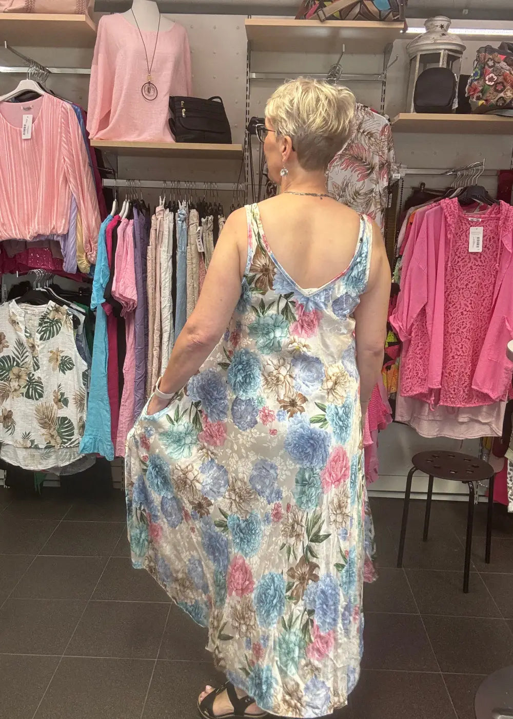 Naisten hihaton silkkimekko kukkakuosilla – syvä V-pääntie, epätasainen helma ja taskut sivusaumoissa.