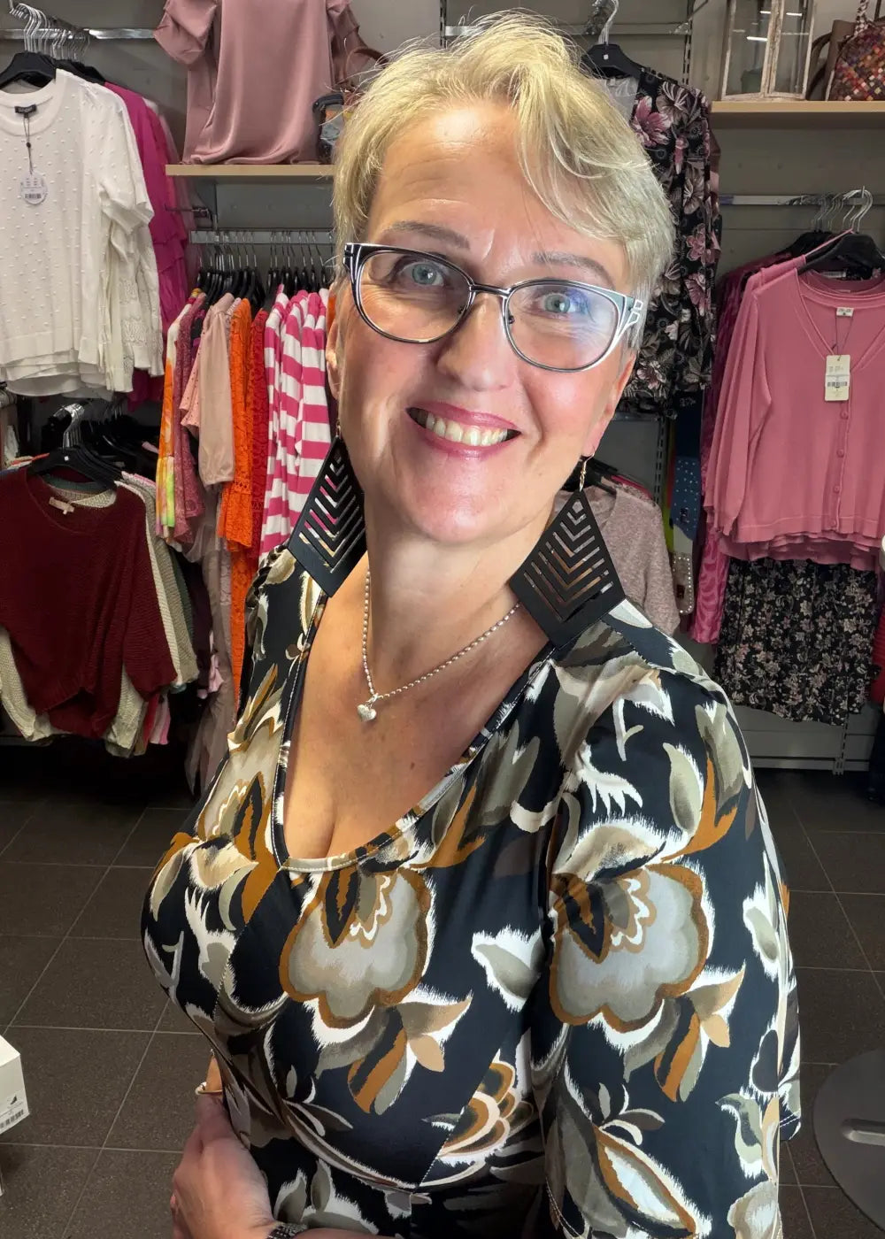 Musta kevyt kuviollinen mekko joustavasta materiaalista, V-pääntie ja kauniisti levenevä kellohelma