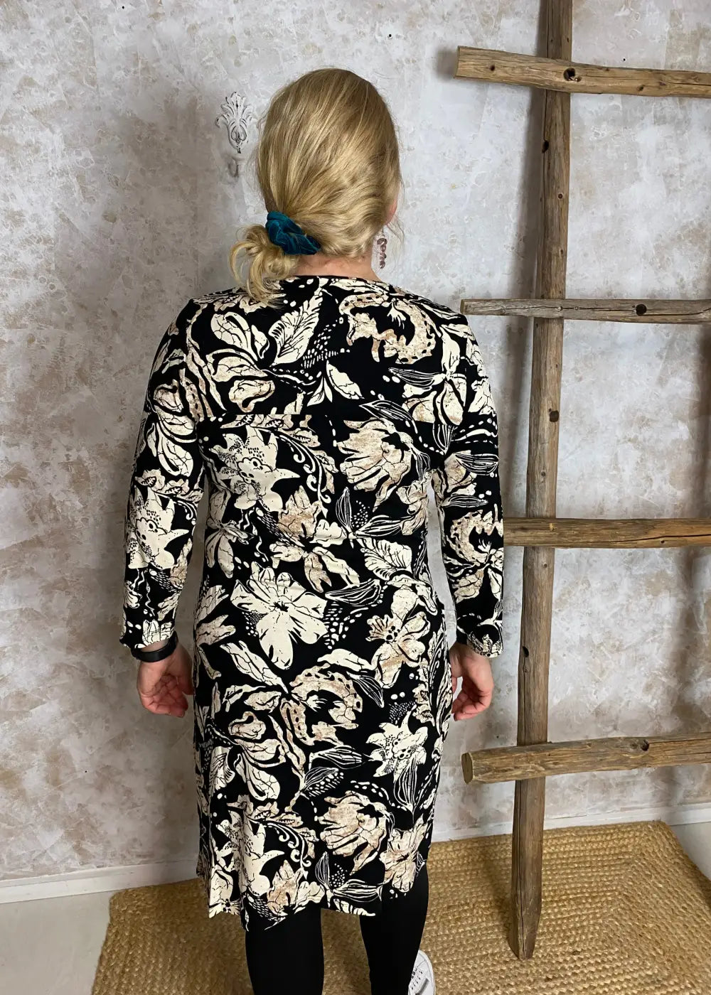 Hiekanvärinen kuviollinen mekko, jossa O-pääntie, vyötäröllä poikkileikkaus, taskut, vajaamittaiset hihat ja levenevä helma