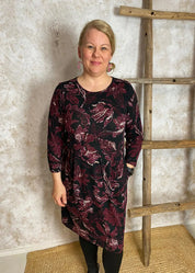 Viininpunainen kuviollinen mekko, jossa O-pääntie, vyötäröllä poikkileikkaus, taskut, vajaamittaiset hihat ja levenevä helma