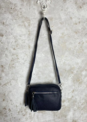 Tyylikäs nahkalaukku aidosta nahasta, säädettävällä hihnalla, vetoketjutaskuilla ja hopeisilla yksityiskohdilla.