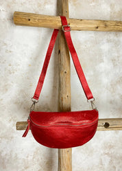 Rohkea punainen nahkalaukku kimaltavalla kuosilla, säädettävä ja irrotettava nahkahihna, vetoketju, kangasvuori ja sisätasku