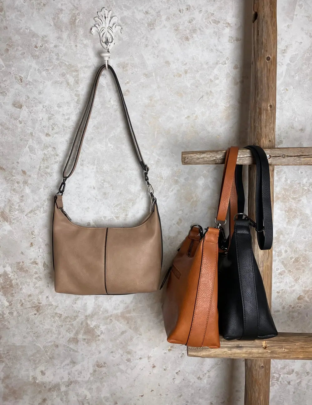 Tyylikäs ja käytännöllinen olkalaukku kestävää keinonahkaa, säädettävällä hihnalla ja useilla vetoketjutaskuilla.