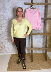 Pehmeä neule V-pääntiellä, glitter-painatuksella ja alaspäin kapenevalla mallilla, laskettu olkalinja ja kultakirjailut resoreissa