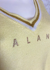 Pehmeä neule V-pääntiellä, glitter-painatuksella ja alaspäin kapenevalla mallilla, laskettu olkalinja ja kultakirjailut resoreissa