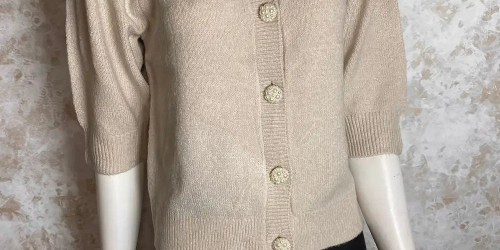 Beige puhvi­hihainen neuletakki helmikoristelluilla napeilla, vajaamittaiset hihat ja O-pääntie naiselliseen tyyliin