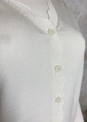 Naisten valkoinen lyhyt neuletakki ohuehkoa pehmeää neulosta, edessä napit, suora malli, täyspitkät puffihihat ja avara V-pääntie