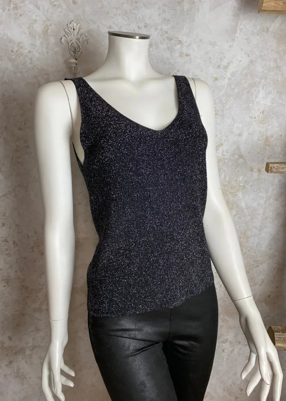 Säihkyvä hihaton neuletoppi naisille, kimaltava kuosi, suora malli ja syvä V-kaula-aukko – tyylikäs arkeen ja juhlaan.