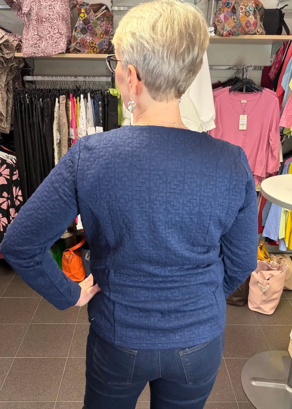 Tummansininen tekstuuripintainen neulosjakku paksusta joustavasta materiaalista, vetoketju edessä ja taskut