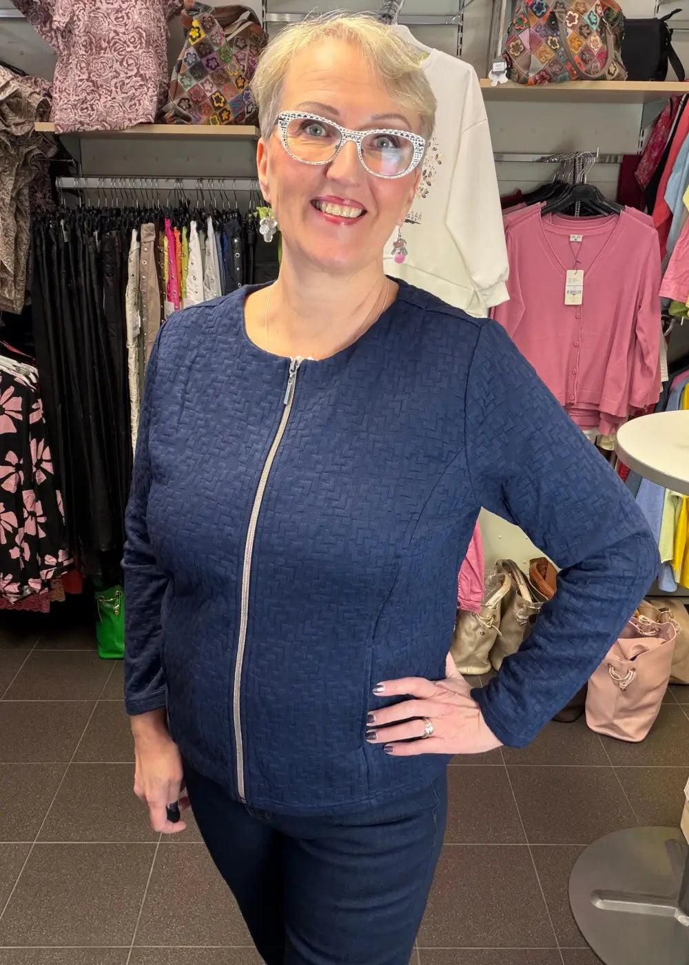 Tummansininen tekstuuripintainen neulosjakku paksusta joustavasta materiaalista, vetoketju edessä ja taskut