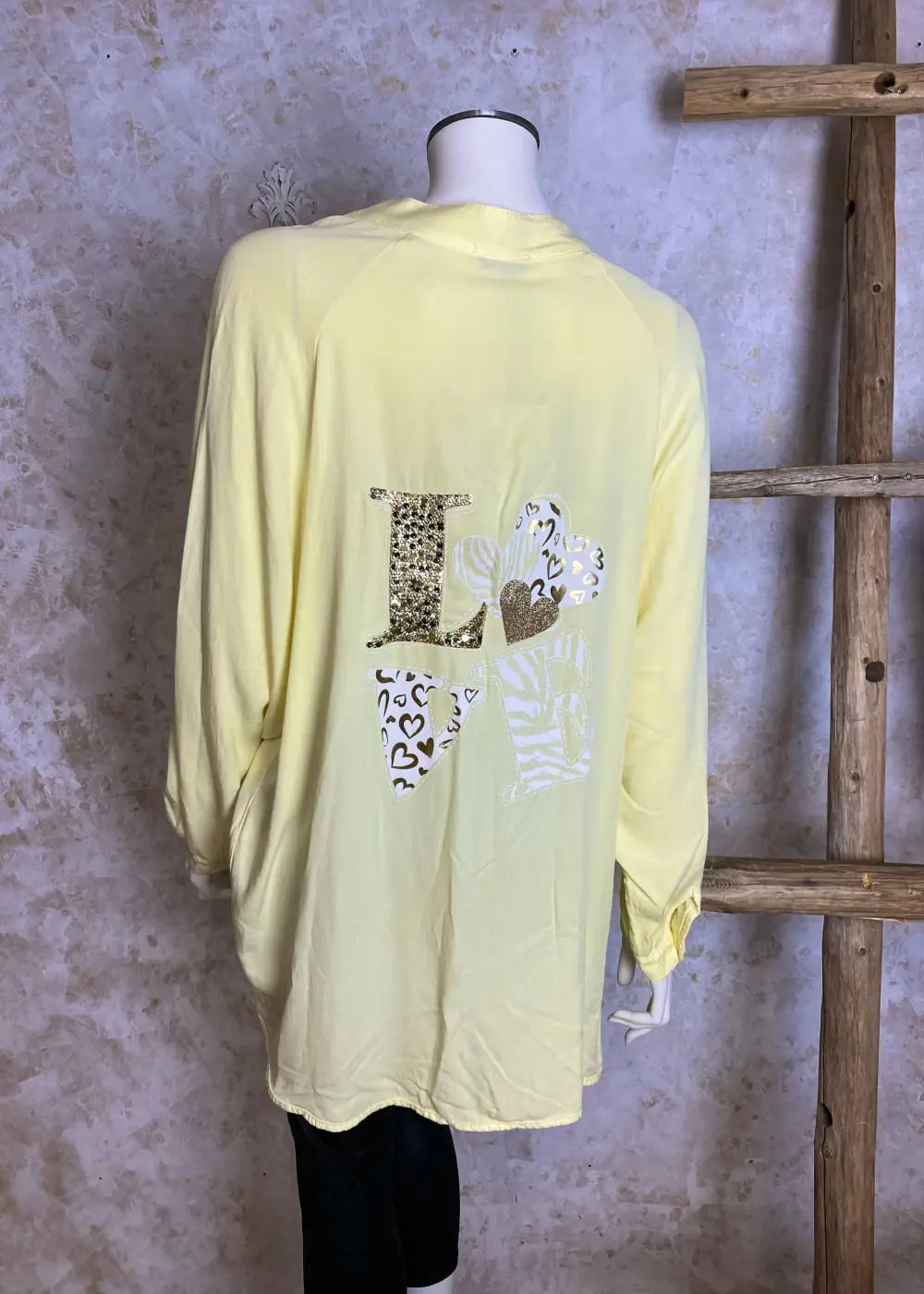 Huolettoman kevyt pitkä pusero selkäyksityiskohdalla, LOVE-koristeteksti, suora malli, lyhyt napitus ja pidempi helma takana