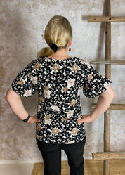 Naisten hurmaava trikoopaita beigenä, tiheä kukkakuvio, pehmeä ja joustava materiaali, naisellinen malli, V-pääntie, frillahihat ja rypytys