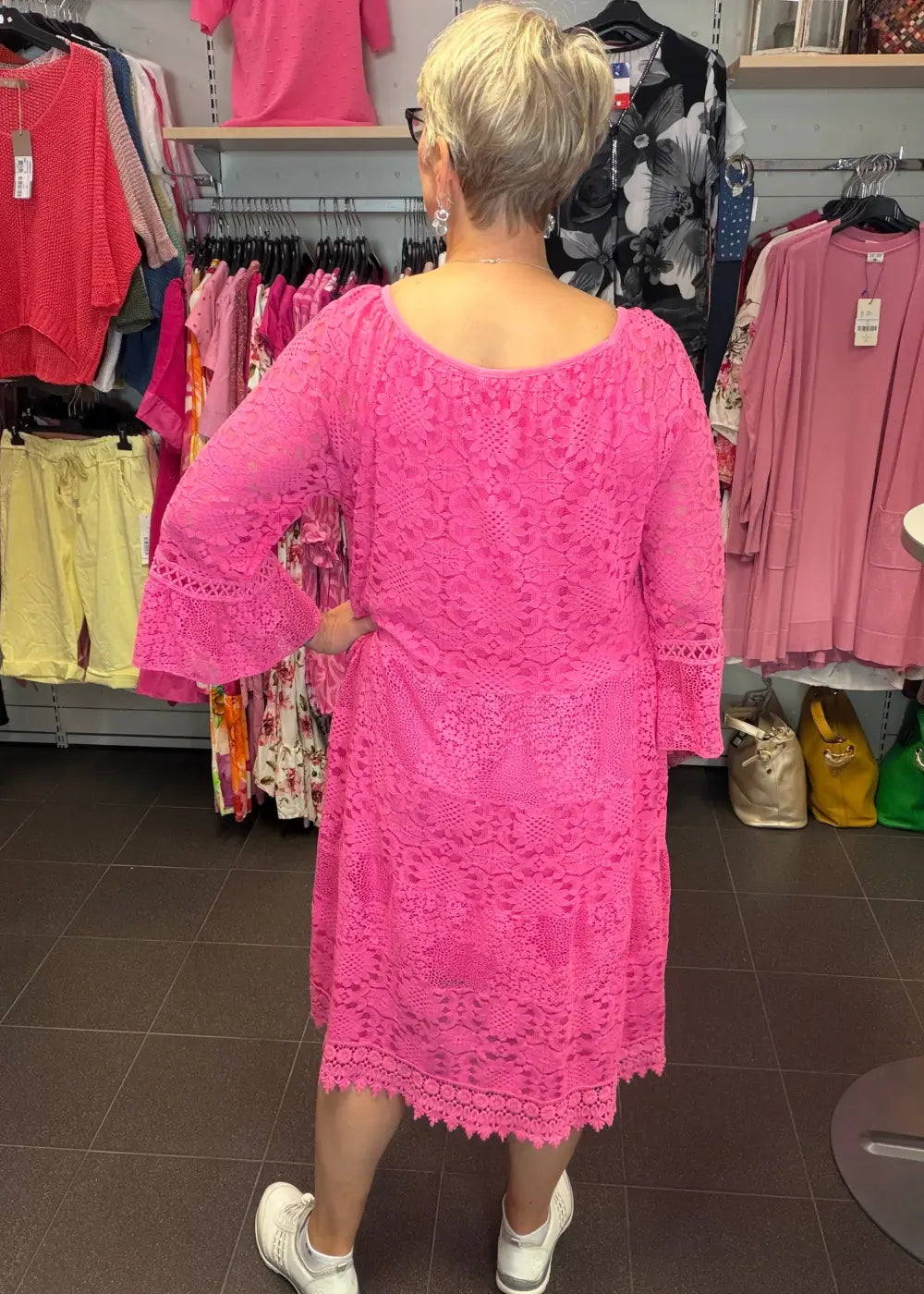 Pinkki pitsimekko A-linjaisella mallilla, läpinäkyvät vajaamittaiset hihat frilloilla ja alusmekko
