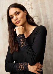 Musta ribbipusero naisellisella istuvuudella, pitsihihansuilla ja täysmittaisilla hihoilla arkeen ja juhlaan.