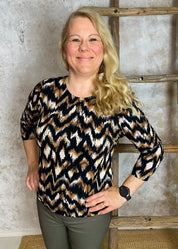 Ruskeasävyinen pusero, kohokuvioitu joustava materiaali, O -pääntie, vajaahihat ja pussimainen helma kuminauhalla.