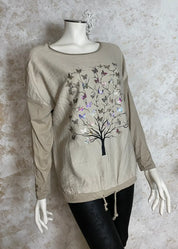 Värikäs elämänpuu-paita, jossa pitkät hihat, kimaltava etukuvio, laskettu olkalinja ja säädettävä helma.