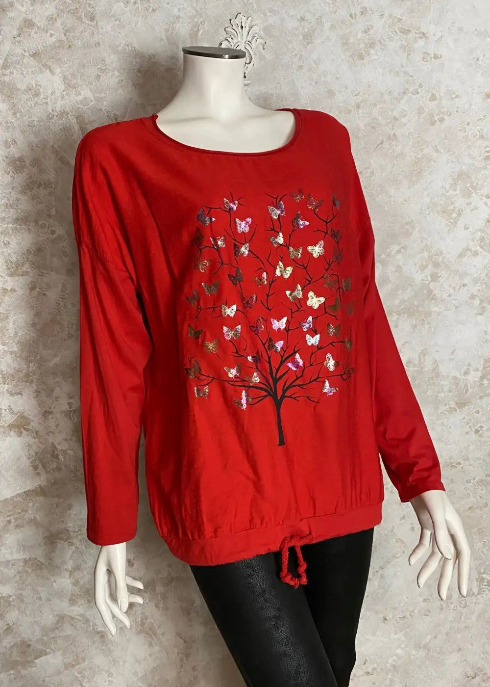 Värikäs elämänpuu-paita, jossa pitkät hihat, kimaltava etukuvio, laskettu olkalinja ja säädettävä helma.