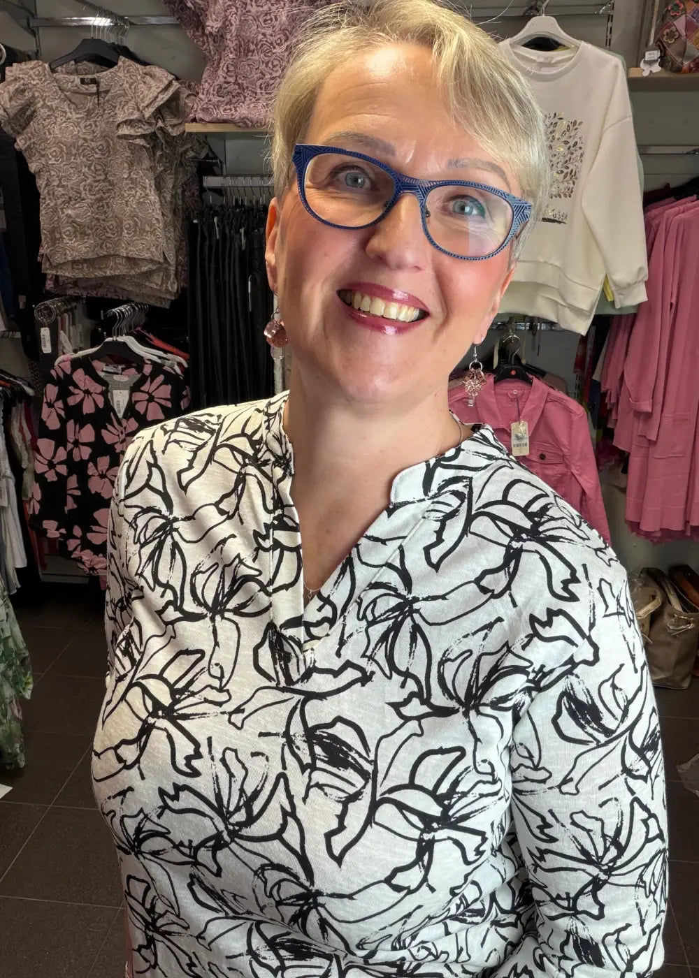 Naisten mustavalkoinen paitapusero joustavasta materiaalista, V-pääntie ja pieni kaulus, vajaamittaiset hihat ja kaareva helma