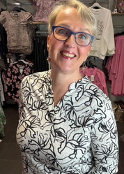 Naisten mustavalkoinen paitapusero joustavasta materiaalista, V-pääntie ja pieni kaulus, vajaamittaiset hihat ja kaareva helma